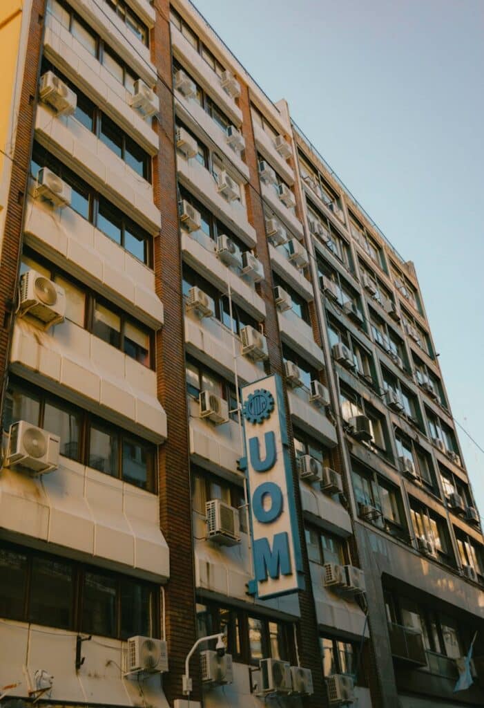 High-rise urban building with multiple air conditioners on facade.